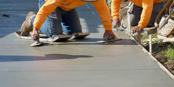 Construction workers putting finishing touch on the freshly poured concrete