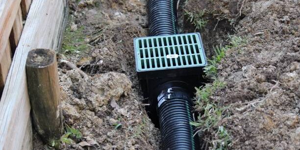 French Drain Drainage ditch. Laying a drainage pipe using rain drainage sewage pipe and box. Earthwork.