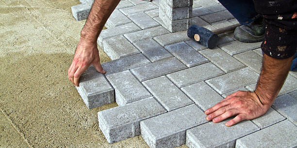 Construction of pavement. Worker puts paving